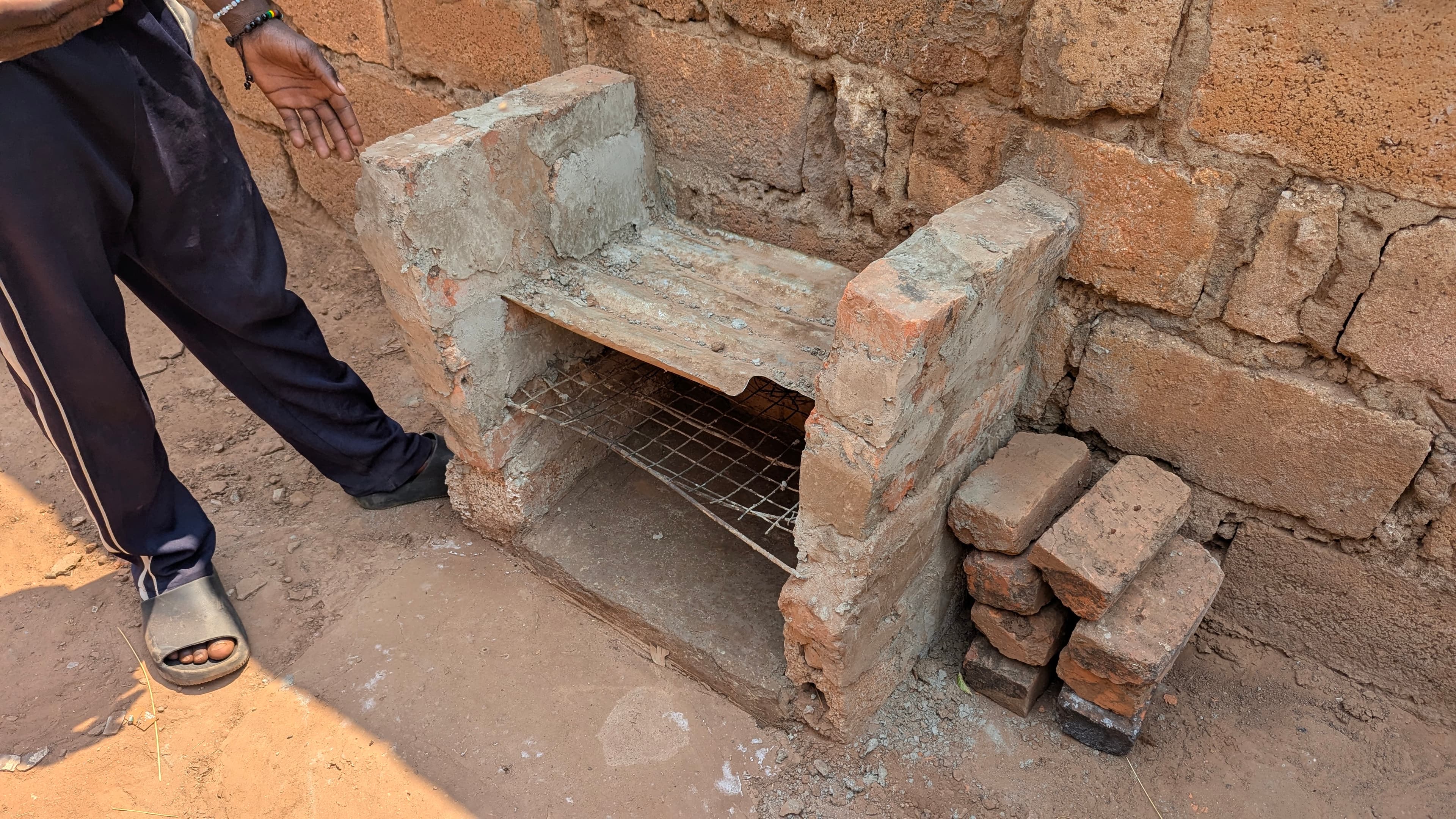 A boy showing his charcoal oven at Nsansa Village